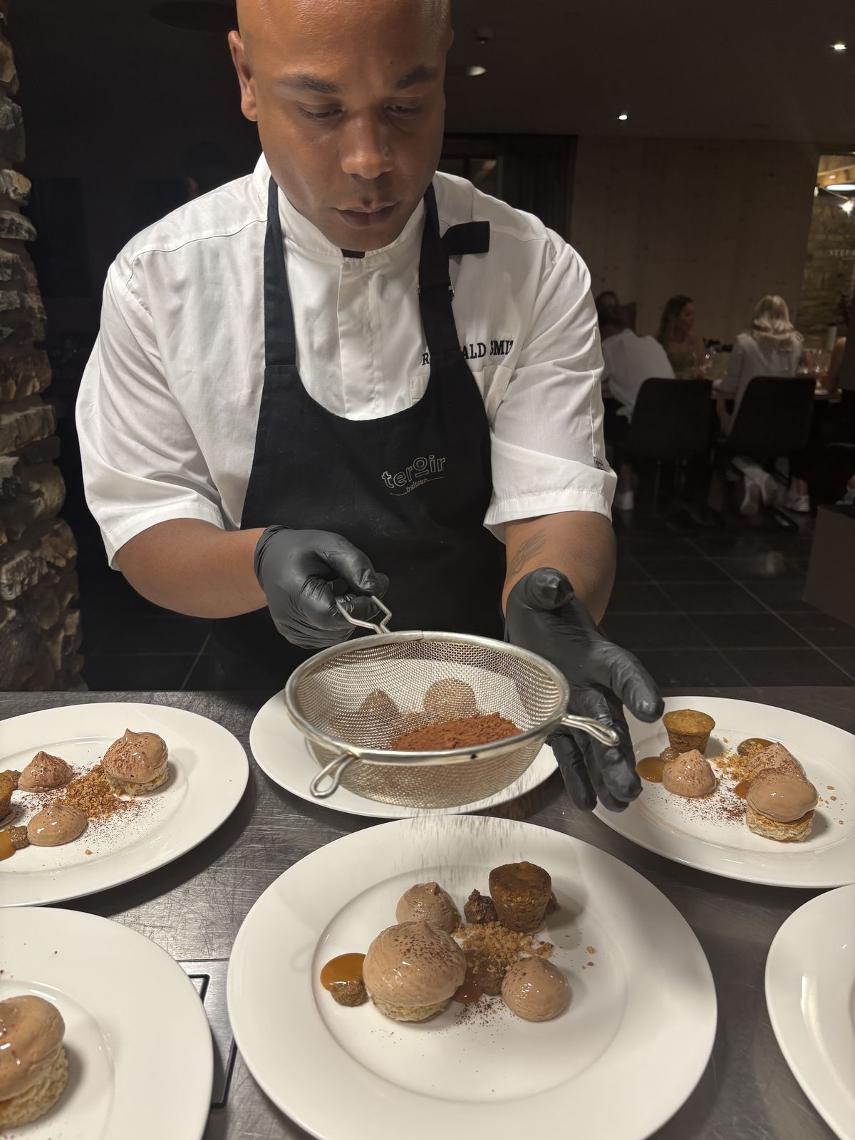 Chef Réginald dresseert een karameldessert in de keuken