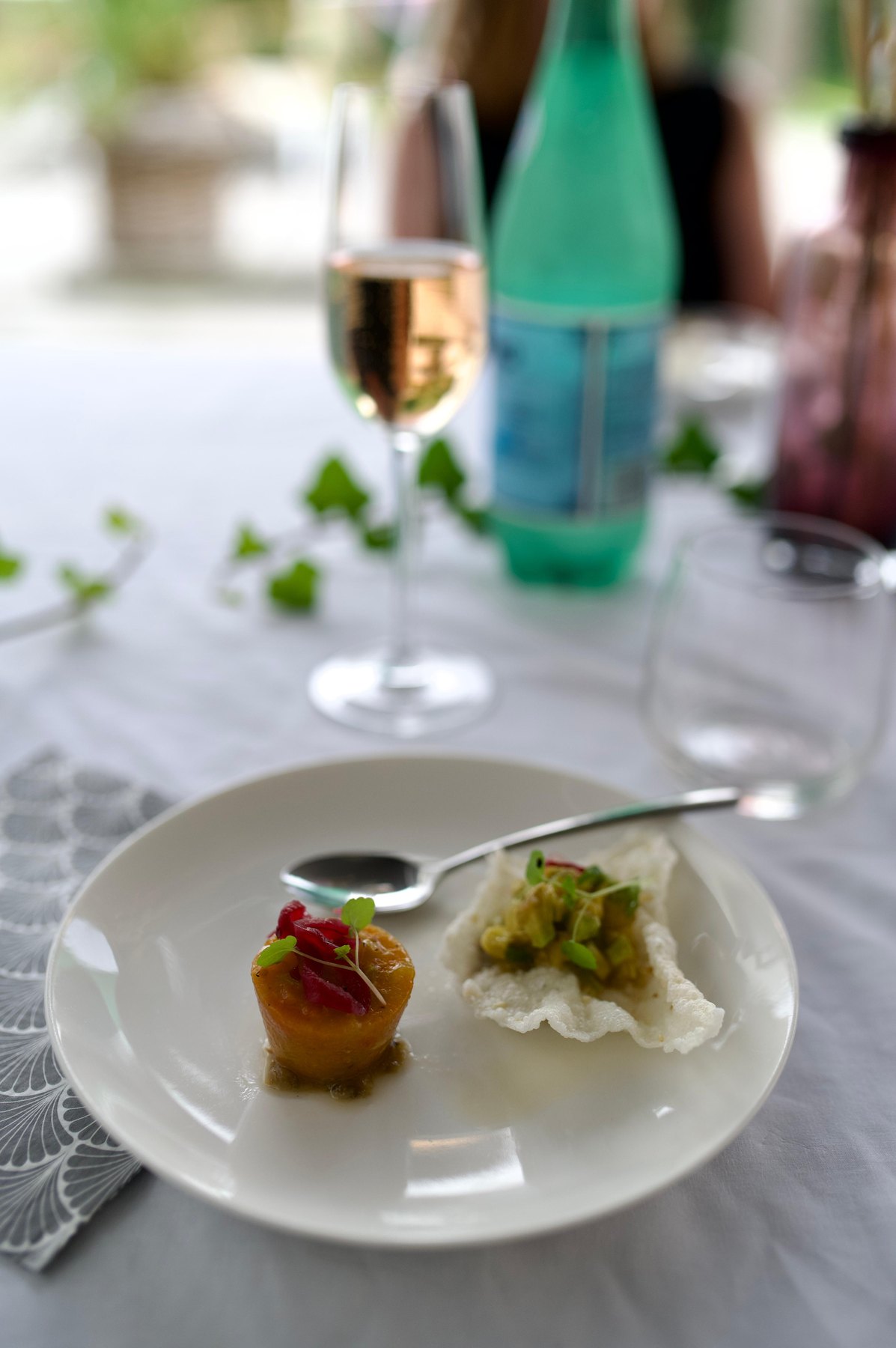 Aperitiefhapje geserveerd met een glas aan tafel